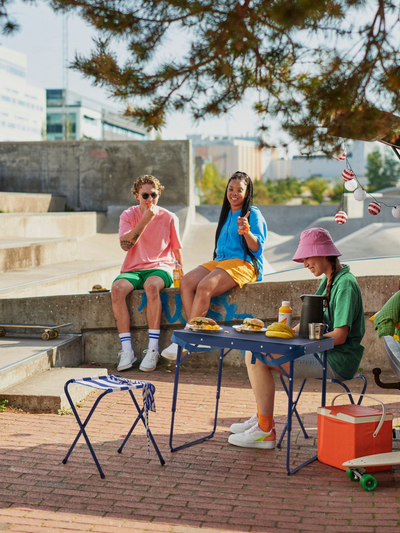 A blue STRANDÖN folding stool outside
