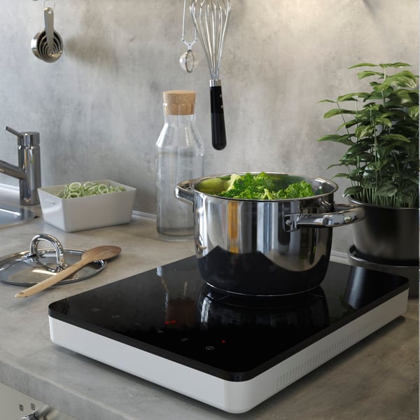 Double-sided white/light grey concrete effect LYSEKIL wall panels in a kitchen, with a TYSEDIL portable induction hob on the counter top with a IKEA365+ pot and other kitchenware on beside it. 