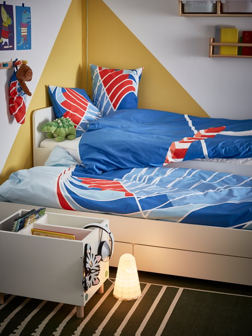 Bedroom with a bed frame with underbed and storage, a duvet cover with pillowcases, and a bedside table shelf unit.