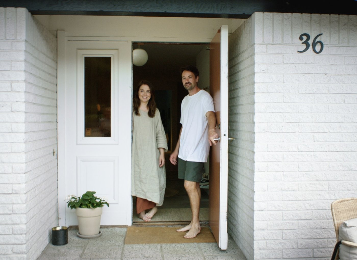 المصمم Mikael Axelsson وامرأة يفتحان باب المنزل. 