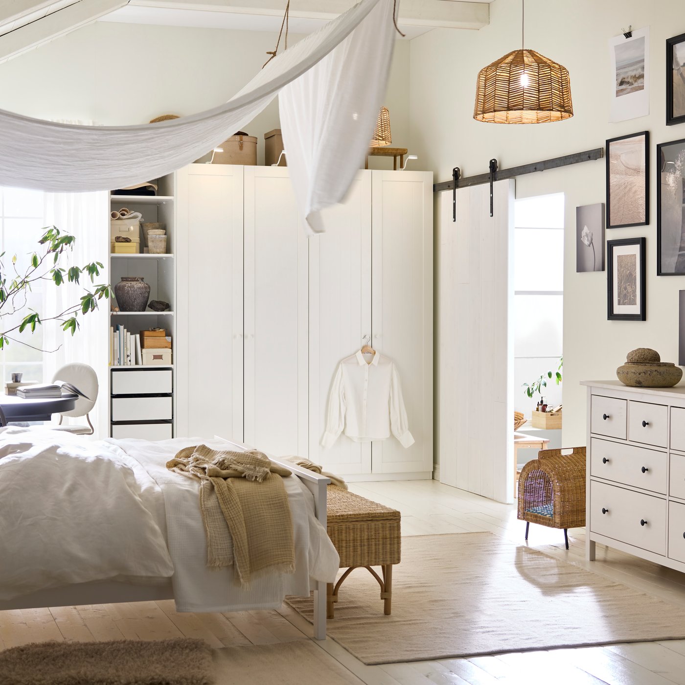 A white HEMNES bed covered in white DYTÅG bed linen and brown cushions with a DYTÅG curtain draped from the ceiling above it.