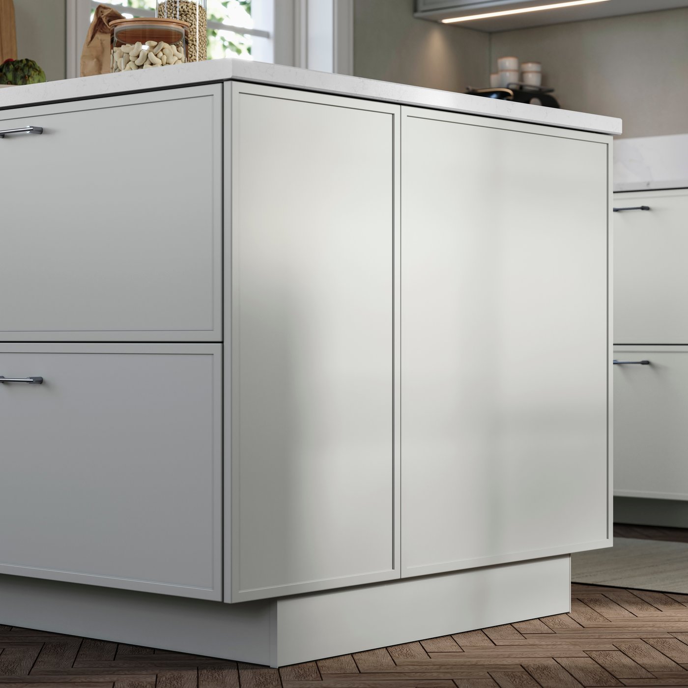 ASPUDDEN light gray fronts and cover panels on a kitchen island, in a modern kitchen with fish bone patterned wooden floors.