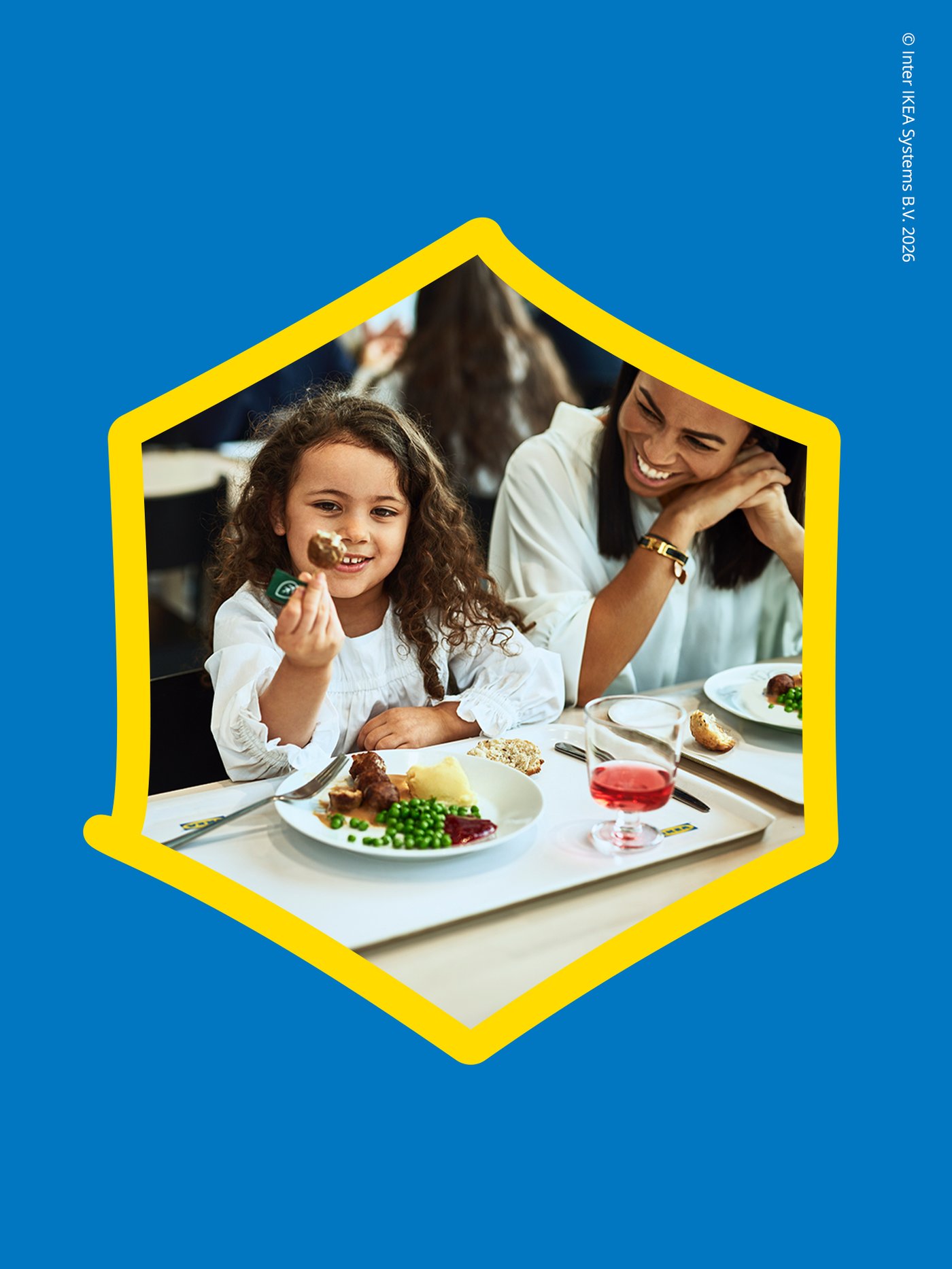 una bambina mangia delle polpette al ristorante IKEA accanto ad una donna