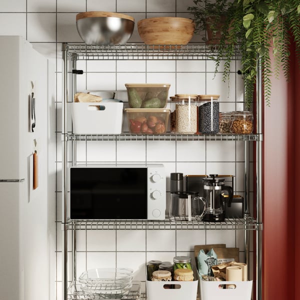 A neatly arranged OMAR shelf section showcasing various containers, bowls, and a microwave in a modern kitchen setting.
