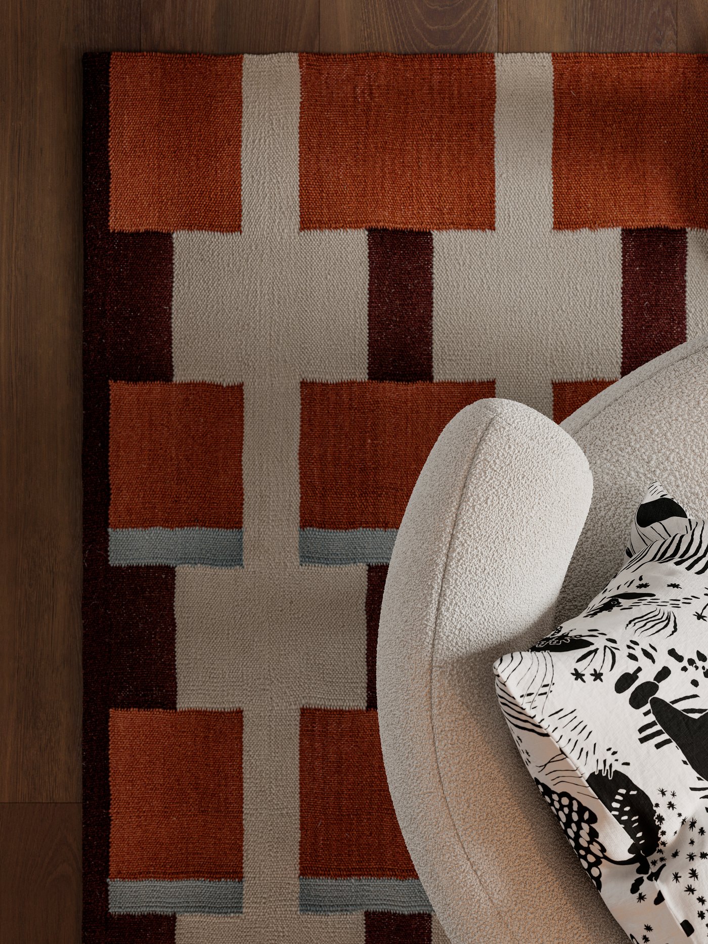 A cushion with a STOCKHOLM 2025 cushion cover lies on a STOCKHOLM 2025 armchair on a STOCKHOLM 2025 rug.