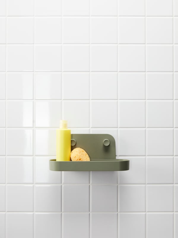 A grey-green ÖBONÄS wall shelf with suction cup