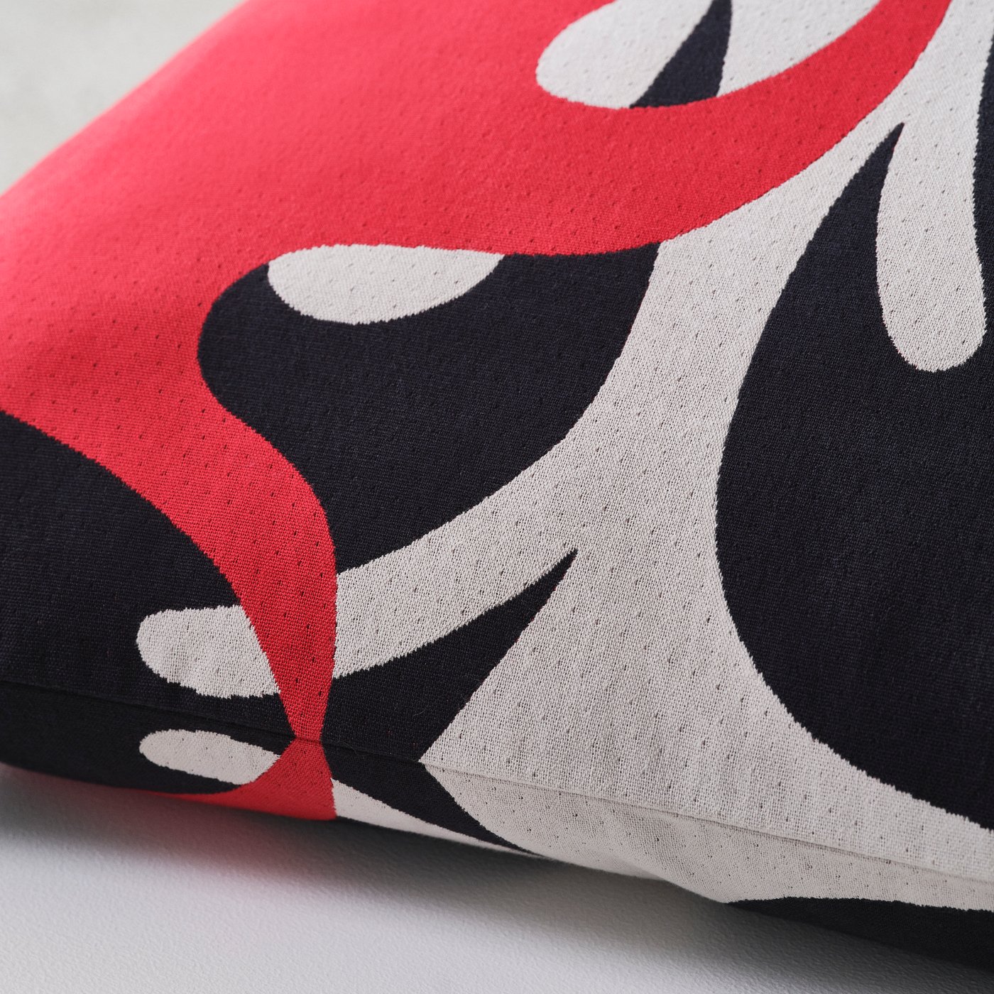 Close up of the grey, red and black pattern of a cushion designed by Igor and Ingrid for IKEA KONSTRUNDA art collection.