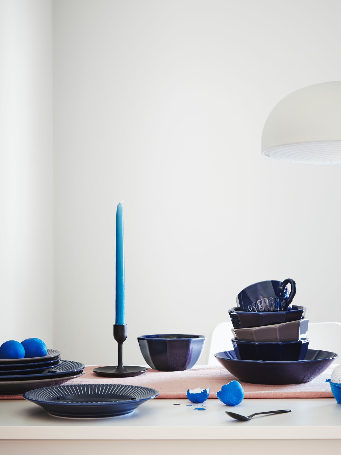 A table setting with STRIMMIG flower-inspired tableware. There is also a plate with two eggs on the table.