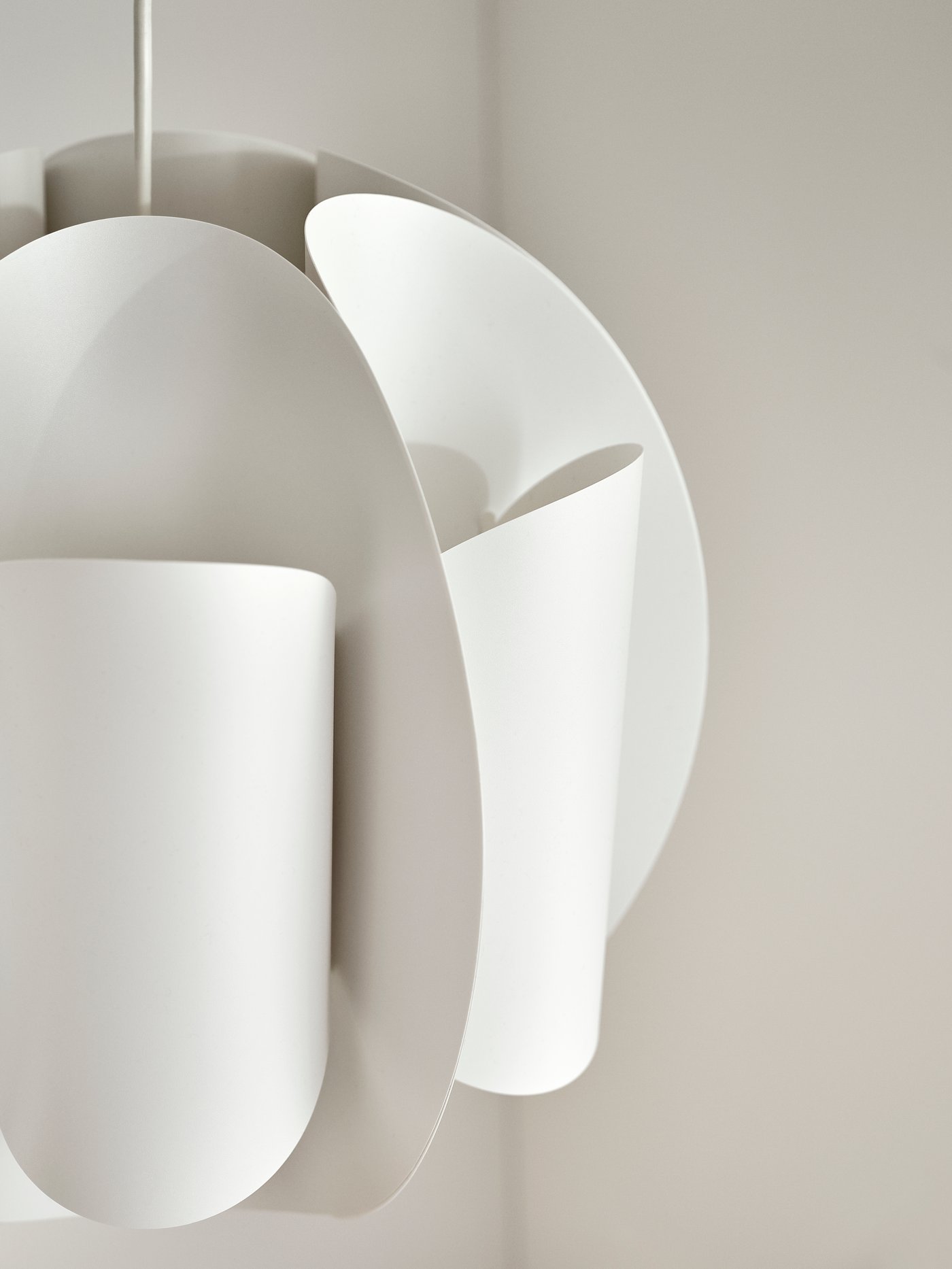 The TRUBBNATE pendant lampshade's futuristic design like its spaceship-like-curves and folds are highlighted in natural light.
