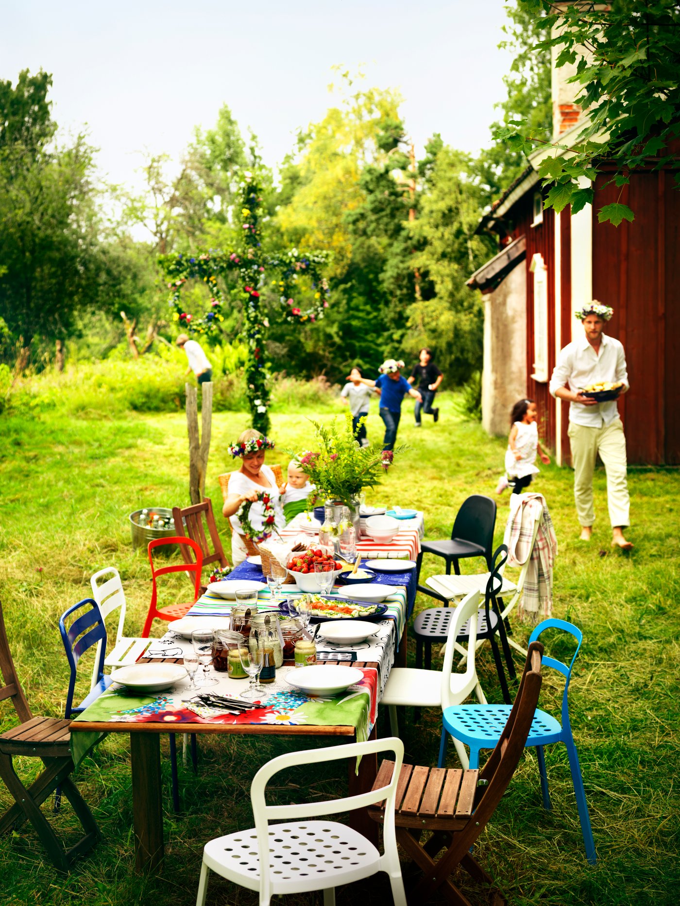 Et langbord er dekket i hagen med masse ulike stoler til.