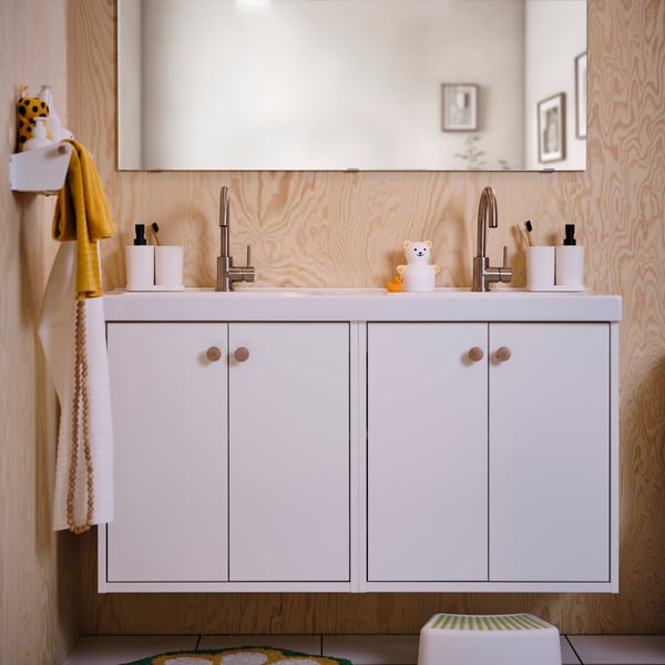 A white HAVBÄCK wash-stand with doors in the bathroom