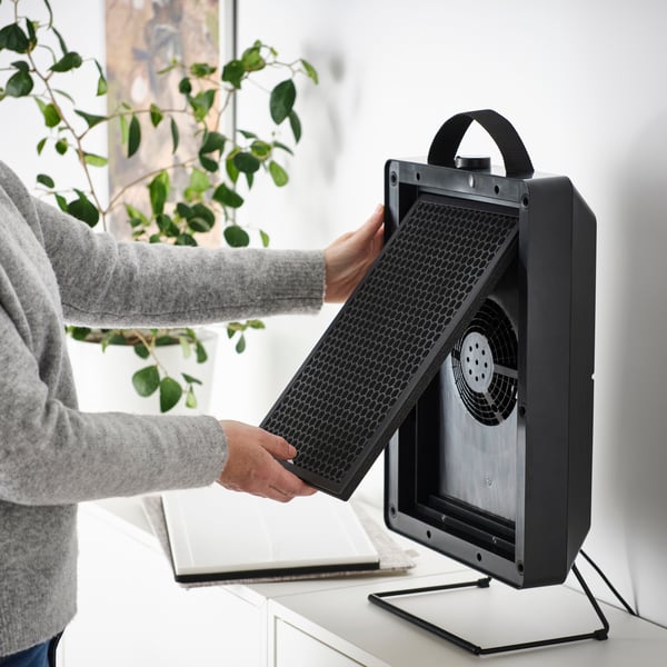 A black FÖRNUFTIG air purifier in the bedroom