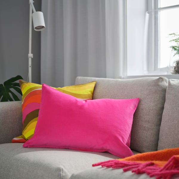 A bright pink SANELA cushion cover