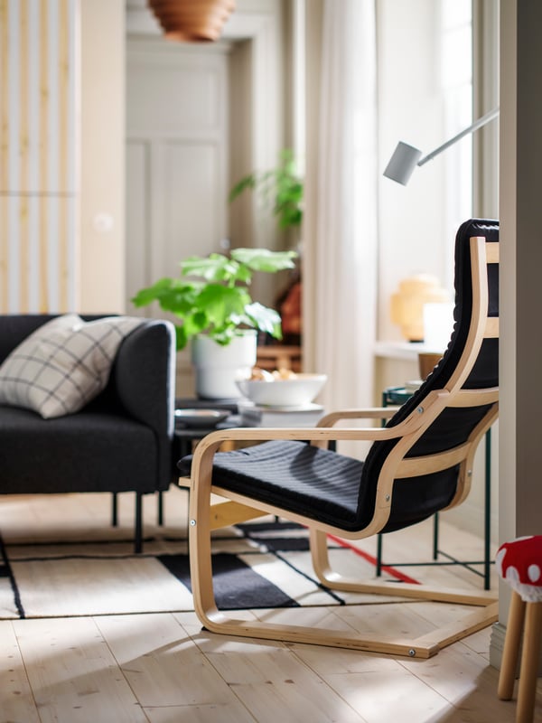 A POÄNG armchair stands near some LILLEHEM seating and a TUNSTA side table with a plant in a pot on top.