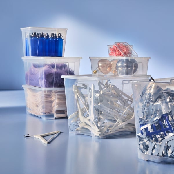 A collection of SAMLA boxes filled with light bulbs, clothes hangers and water bottles.