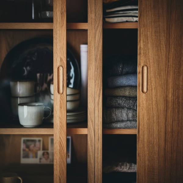 An oak veneer TONSTAD cabinet with sliding glass doors