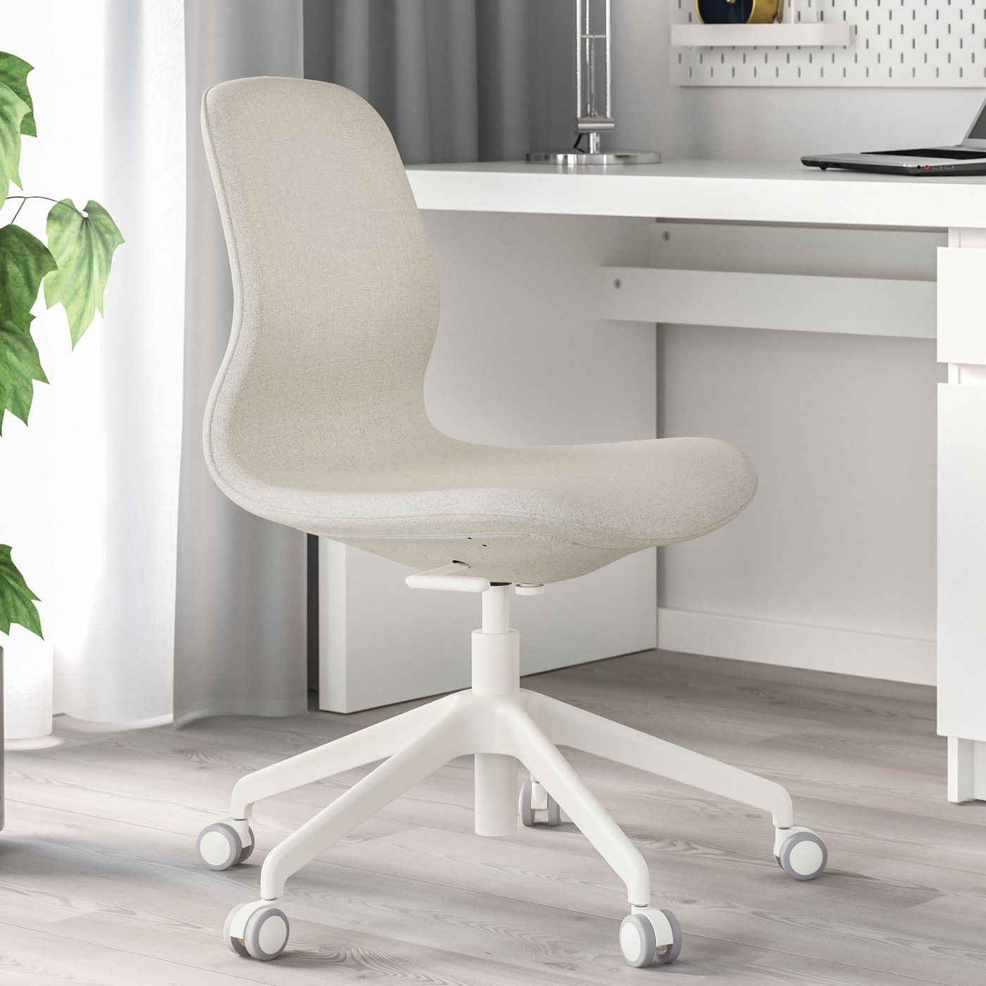 Beige LÅNGFJÄLL kontorsstol vid ett vitt skrivbord i ett vitt rum. 