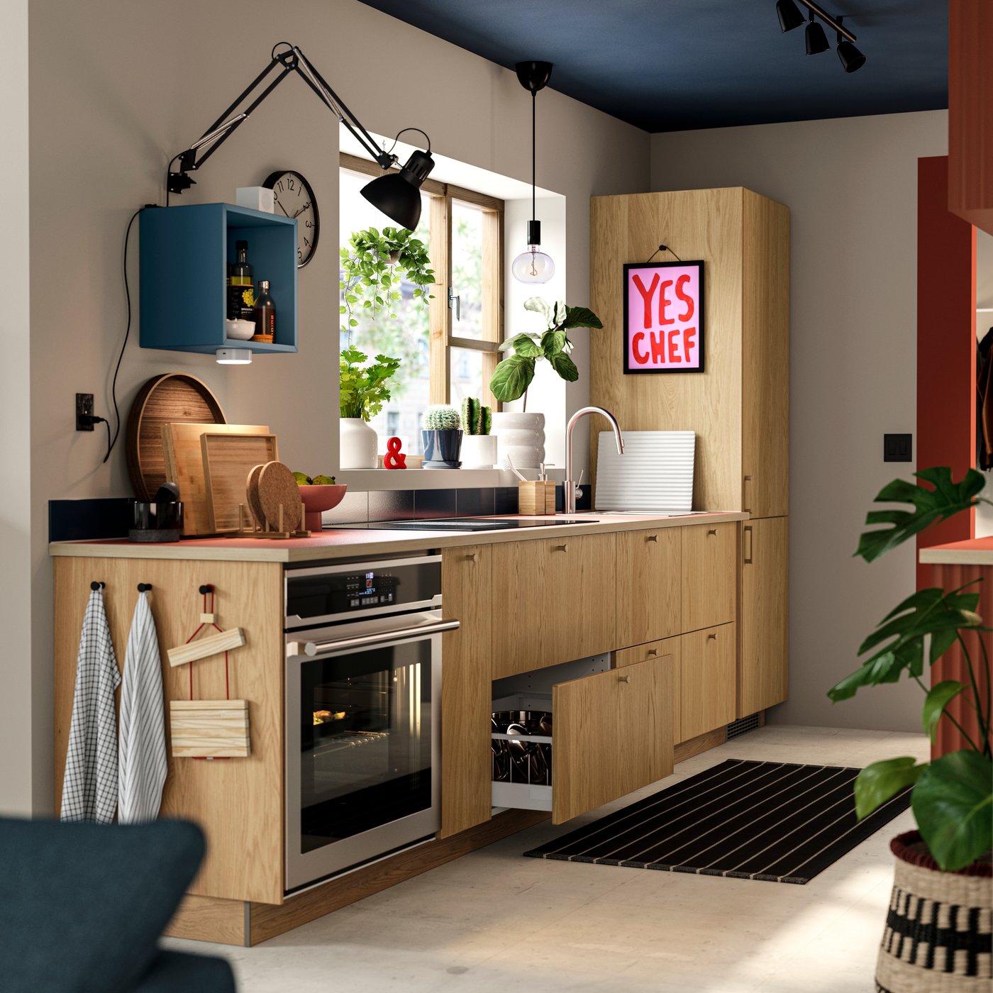 Petite cuisine avec armoires SEKTION dotées de façades SINARP en chêne plaqué, four, évier et réfrigérateur/congélateur encastré.