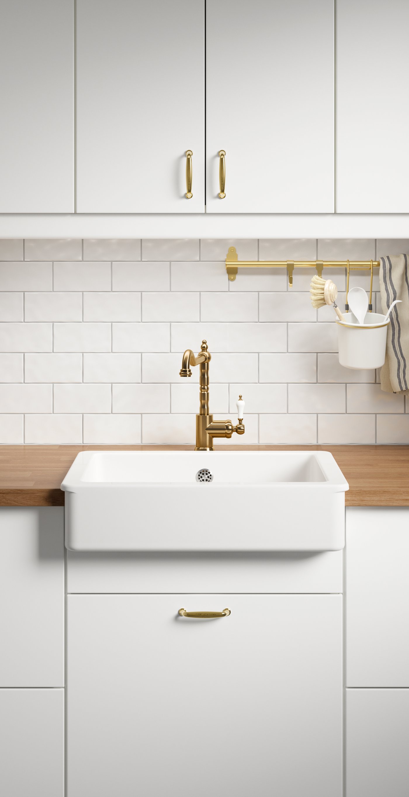 Waschbecken mit weißem Rand und messingfarbener GLITTRAN Mischbatterie verbaut in einer Küche mit weißen Fronten und Arbeitsplatte aus Holz