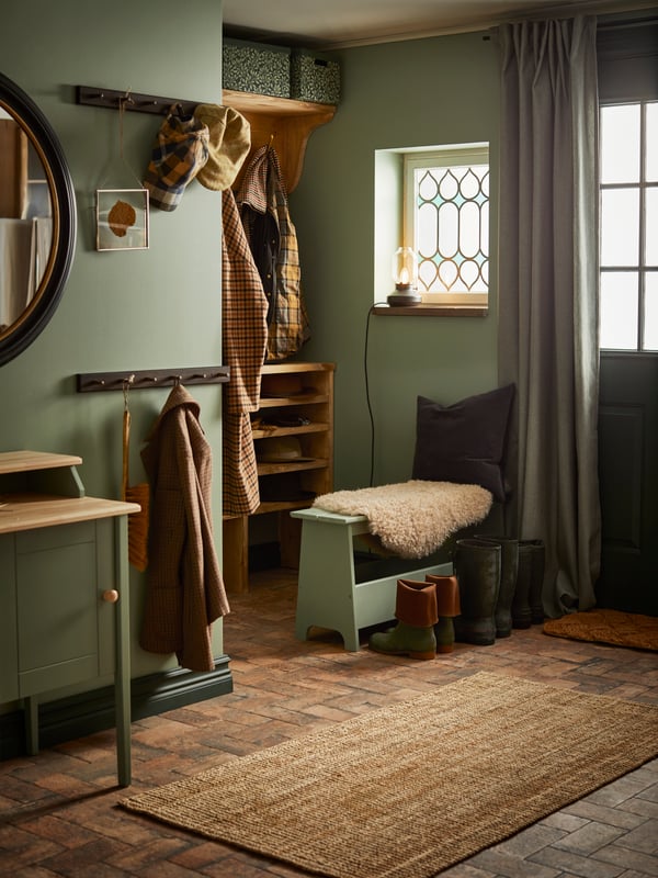 A farmhouse-style hallway with green walls and an acoustic carpet on the floor.