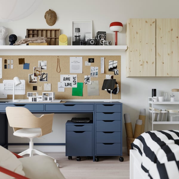 An overview of a small student apartment with the ALEX desk and drawer units in the center, with a swivel chair in the front.
