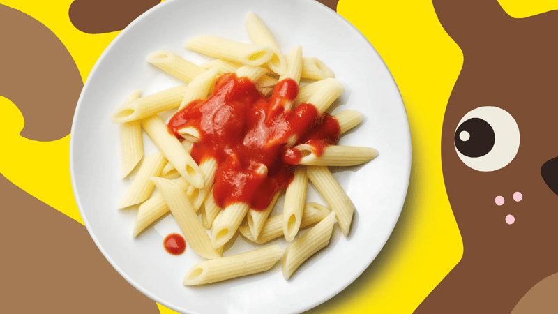 Es ist ein Teller Pasta mit Tomatesauce vor einem bunten Hintergrund. 