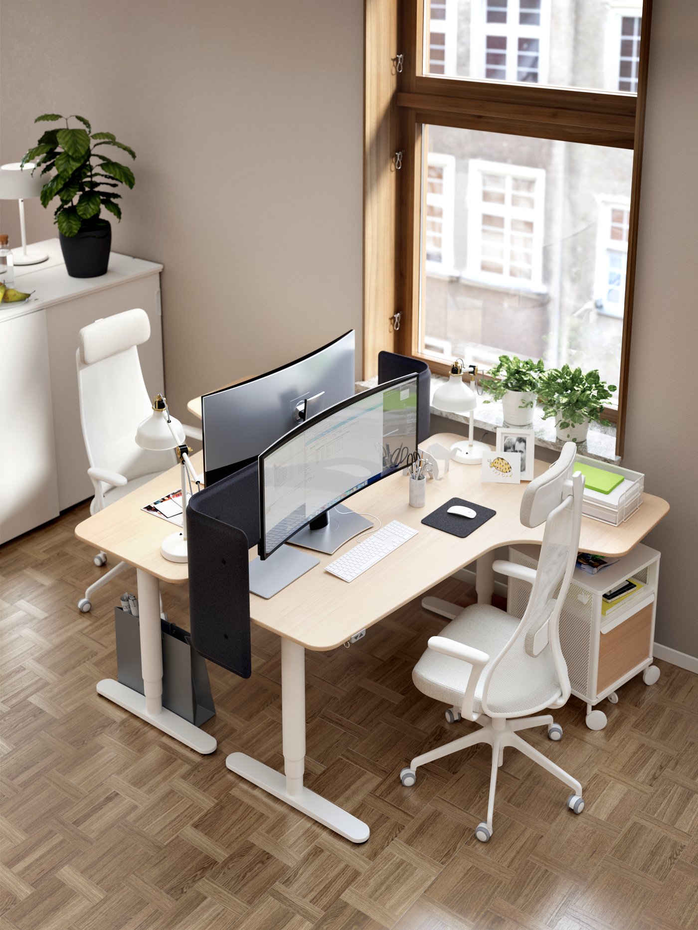 Zwei gegenüberstehende Schreibtische mit weissen Bürostühlen neben einem großen Fenster