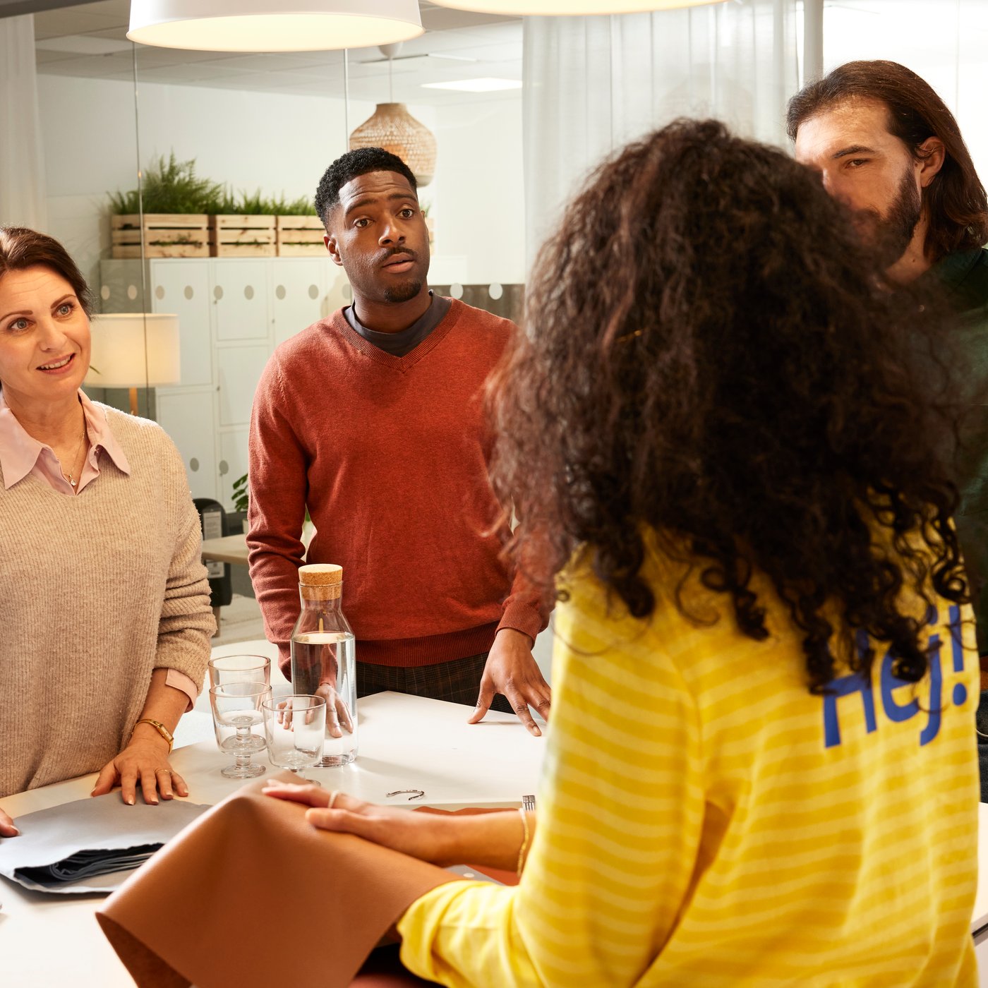 Tres clientes planifican xunto cun empregado IKEA.