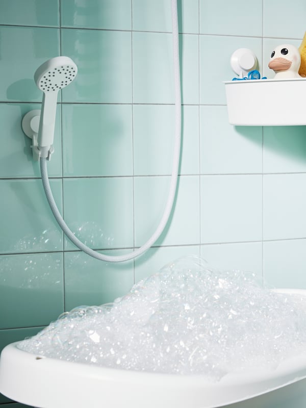 A white/green LÄTTSAM baby bath in the bathroom
