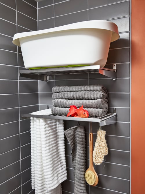 Bathroom with two KUNGSFORS shelves, several FLODALEN bath towels, a FLODALEN hand towel, and a LÄTTSAM baby bath.