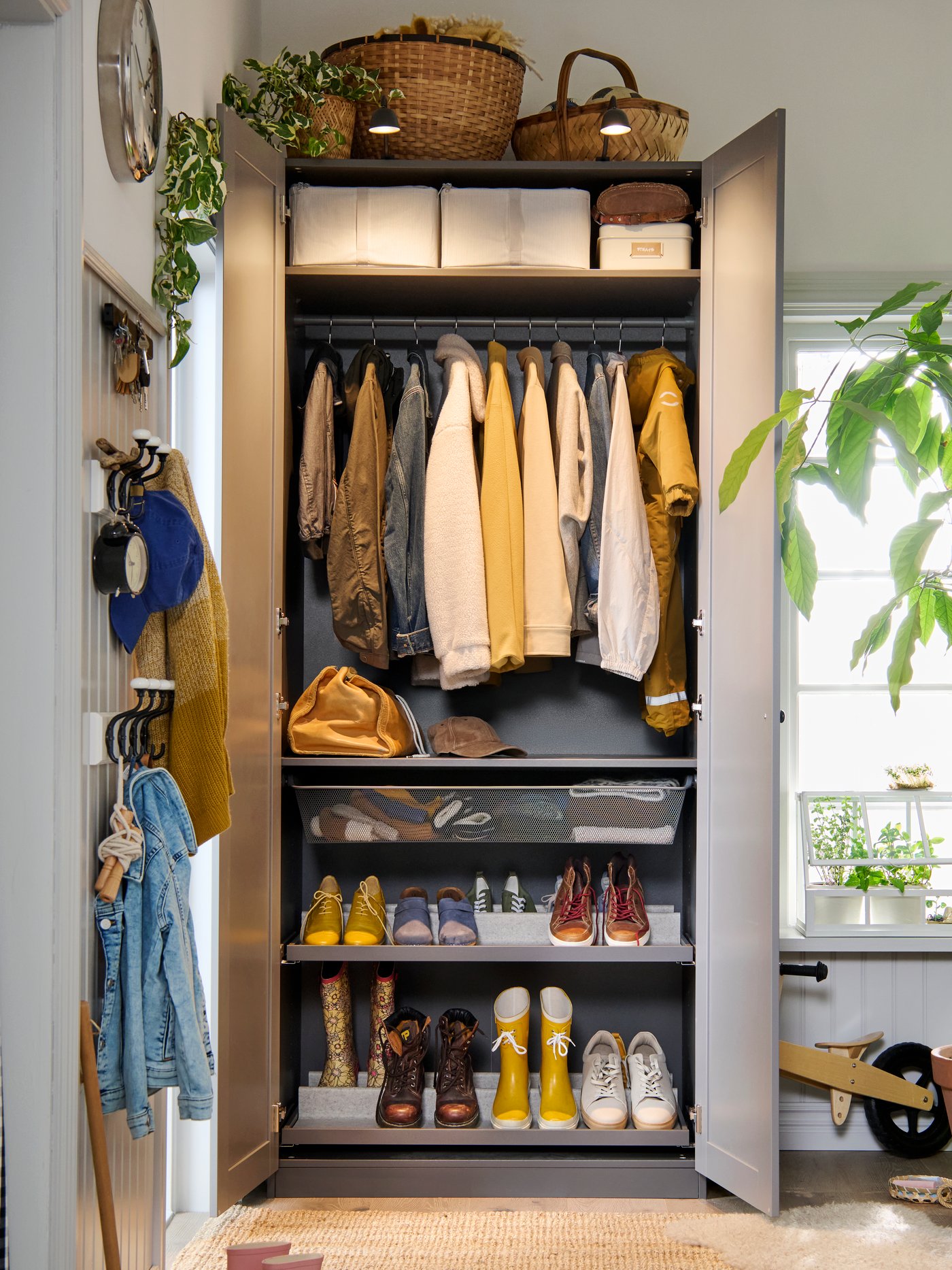 Szara szafa PAX GULLABERG wypełniona ubraniami  z otwartymi drzwiami.