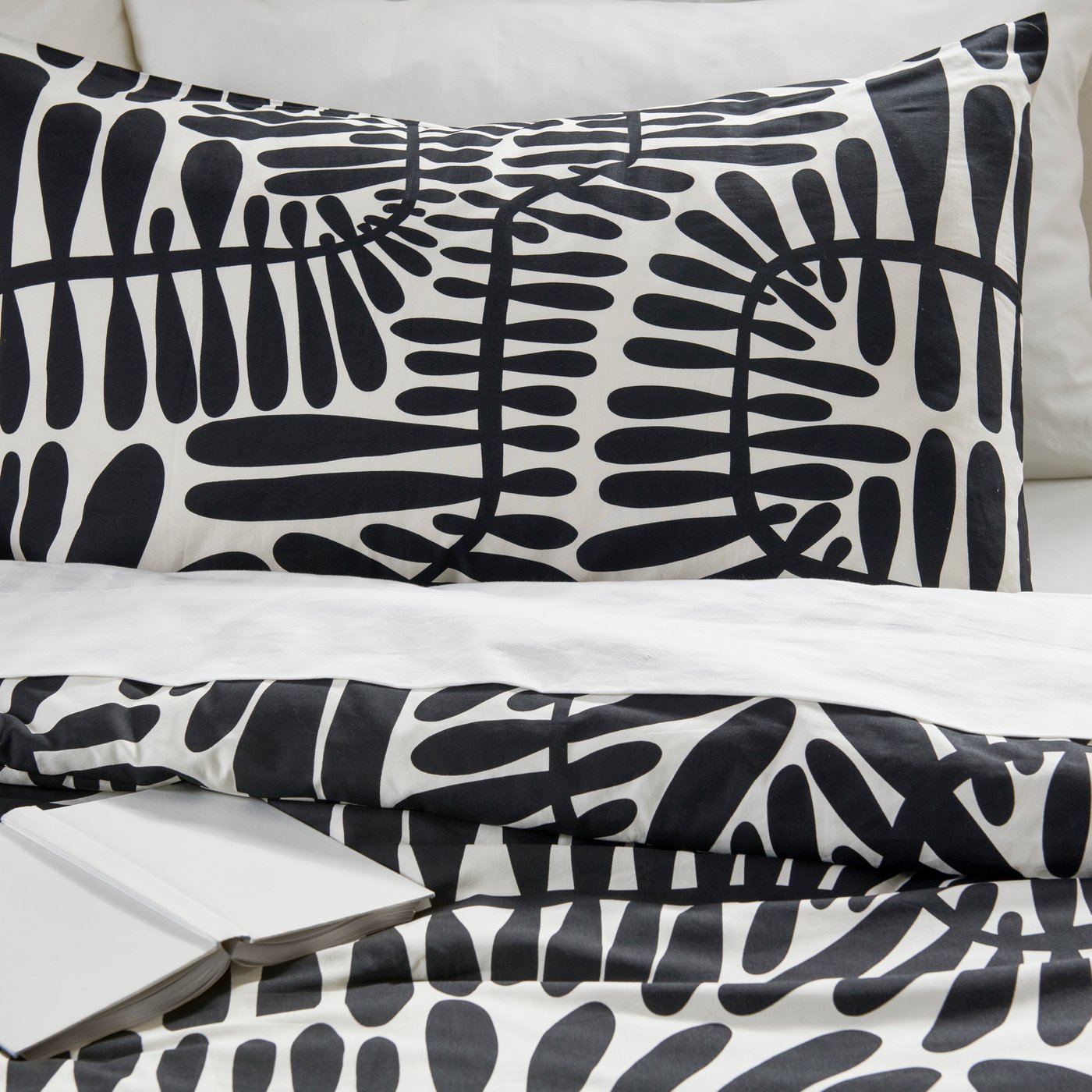 سرير عليه لحاف MAJSMOTT مصمم باللونين الأبيض والأسود.