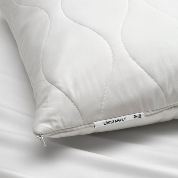 En LÖKSTAMFLY ergonomisk kudde för sido/ryggläge.