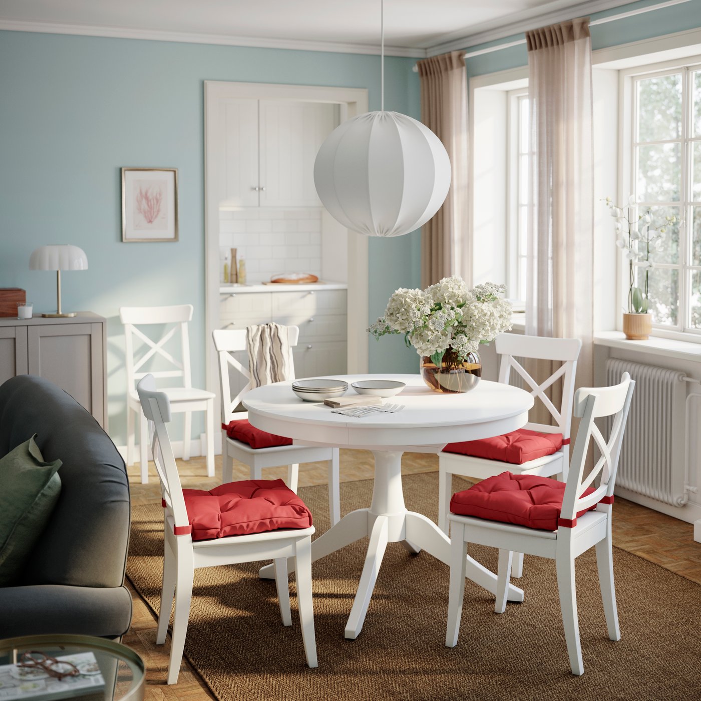 Dining room with round table and a set of 4 chairs with red cushions