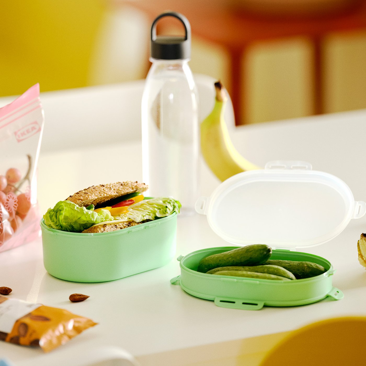 A light green UTBJUDA stackable lunch box for dry food