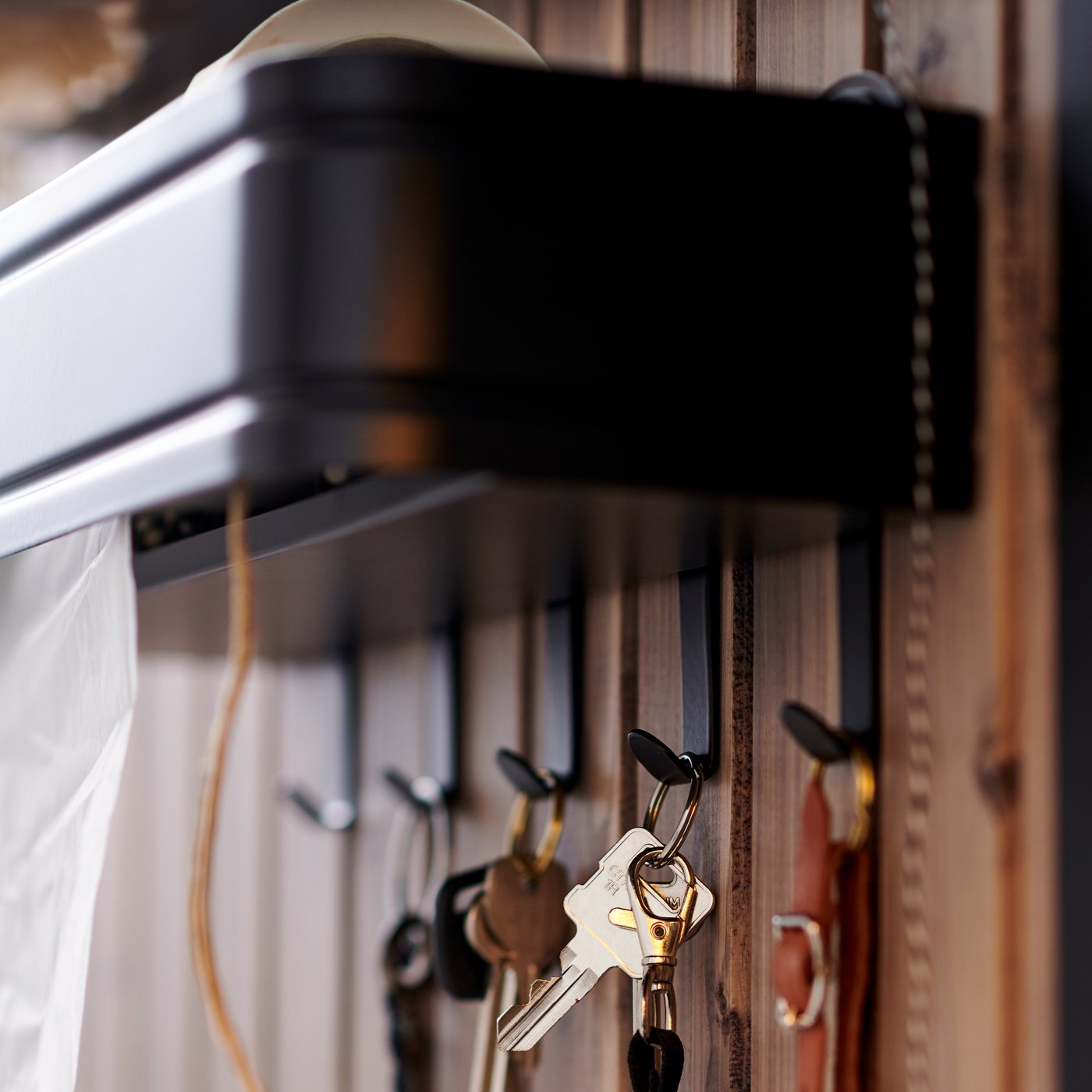 Un colgador de pared LILLASJÖN con 5 ganchos de los que cuelgan llaves.