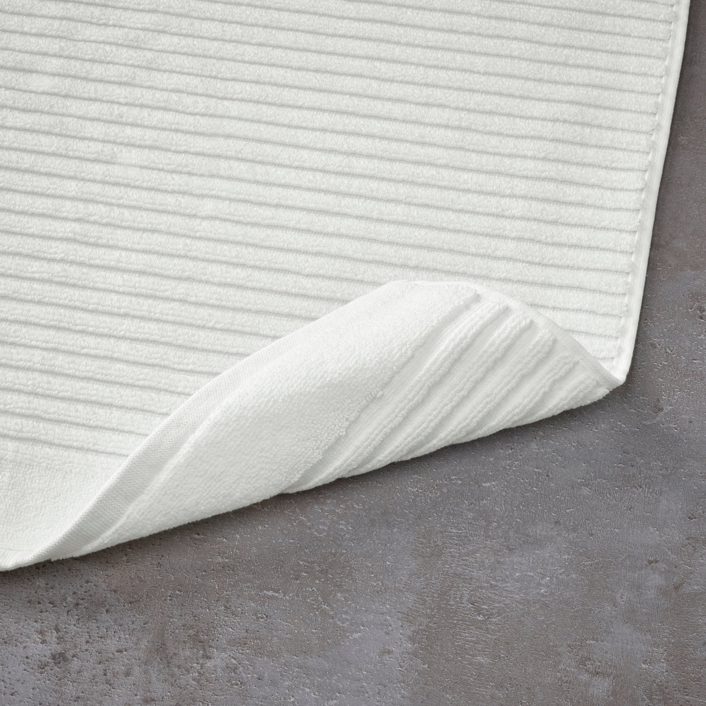 A white ALSTERN bath mat