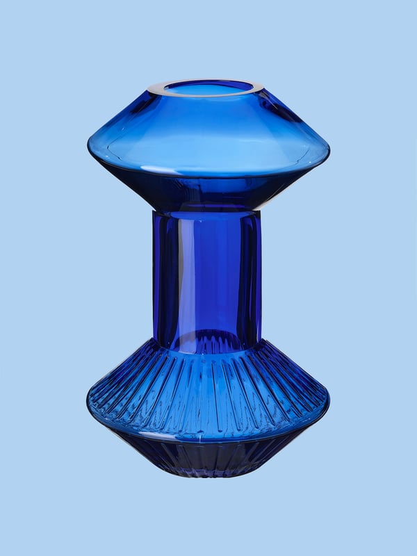 A blue Ikea vase that takes up a large part of the photo against a blue background.