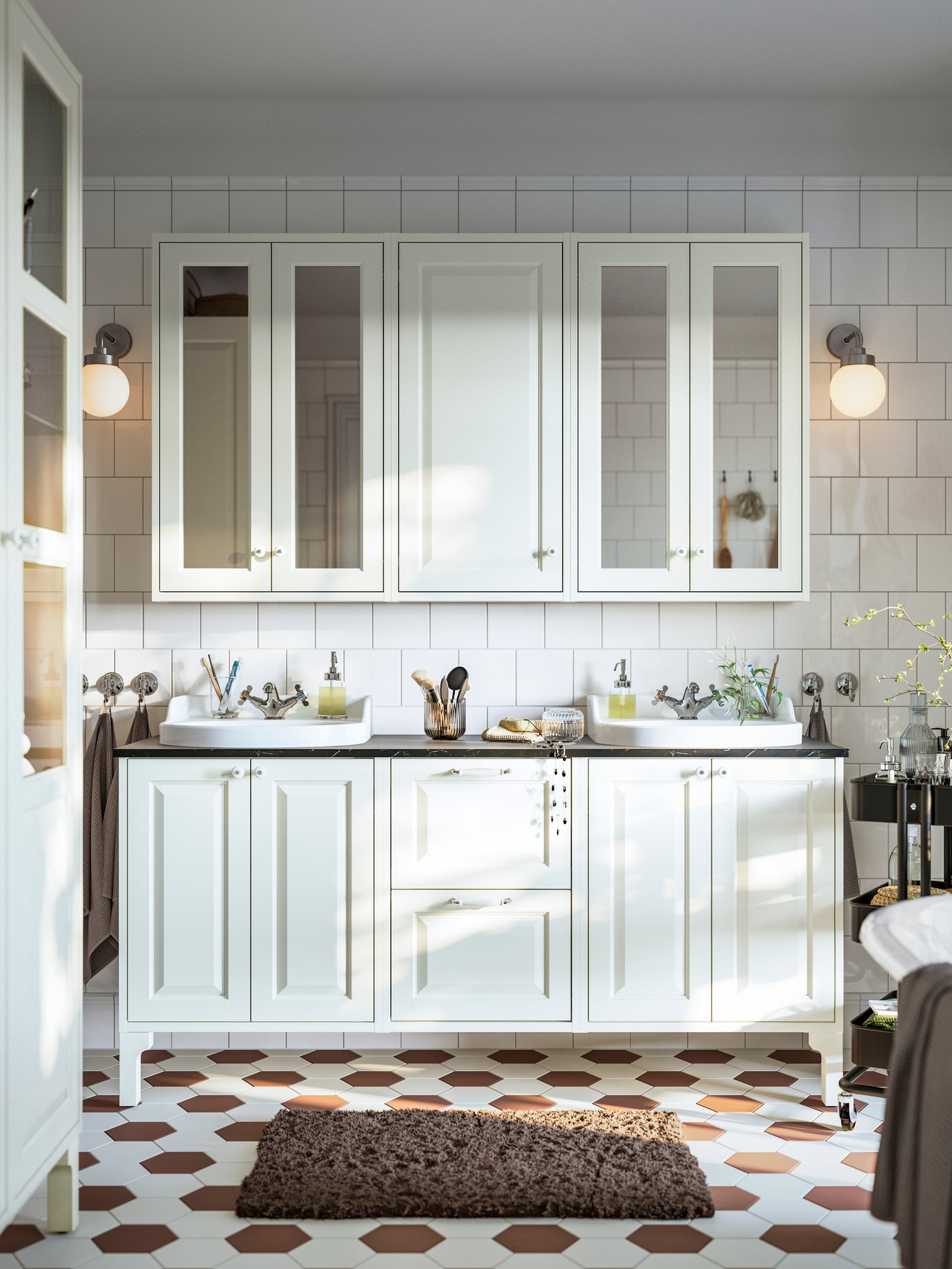A frontal view of a bathroom with white TÄNNFORSEN wash-stands with doors and drawers and mirror cabinets with doors.
