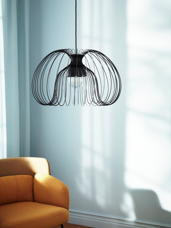 a black wire chandelier from a ceiling
