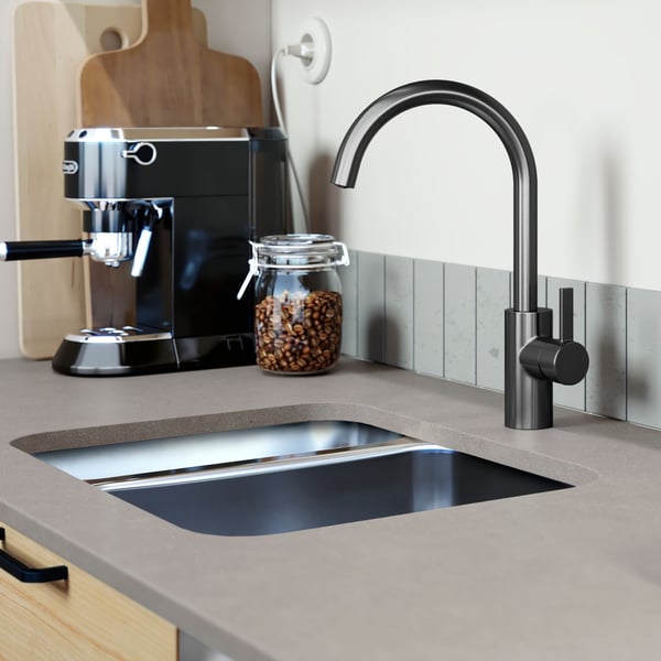 A DELSJÖN kitchen mixer faucet with a pewter effect is mounted on a gray countertop with two sink bowls of stainless steel.