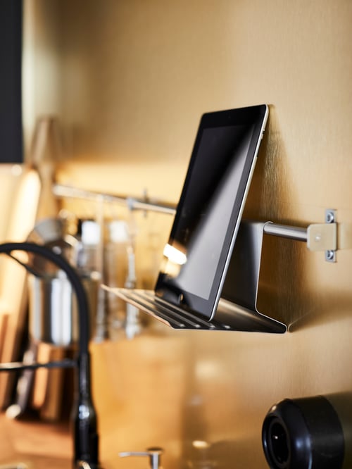 Kitchen with orange wall, KUNGSFORS suspension rail fixed on wall, KUNGSFORS tablet stand, and tablet.