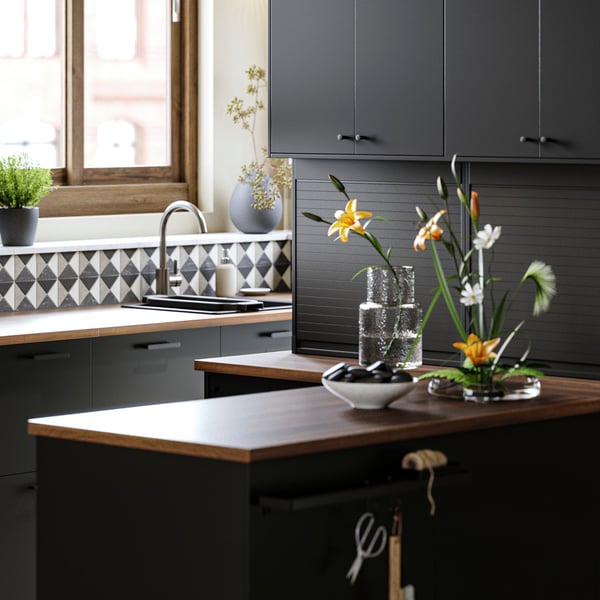 Kuchnia z drzwiami NICKEBO w kolorze antracytowym, okapem ściennym FINSMAKARE w kolorze czarnym oraz doniczkami PERSILLADE.