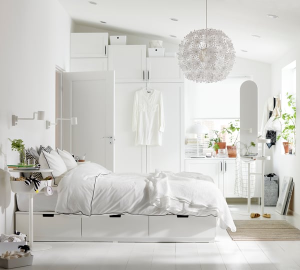 A white NORDLI bed frame with storage in the bedroom