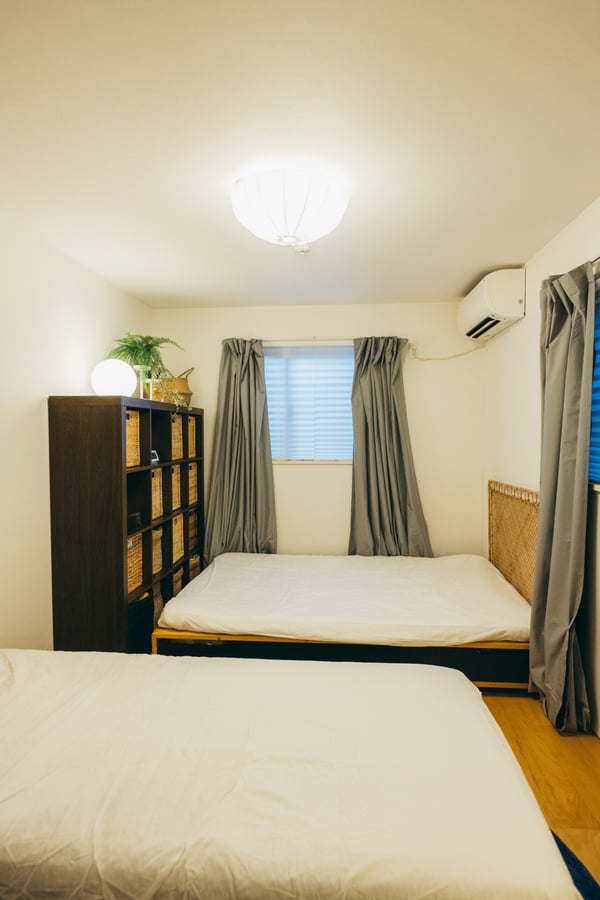ベッドが2つ置かれた部屋の角に、収納棚が置かれている。