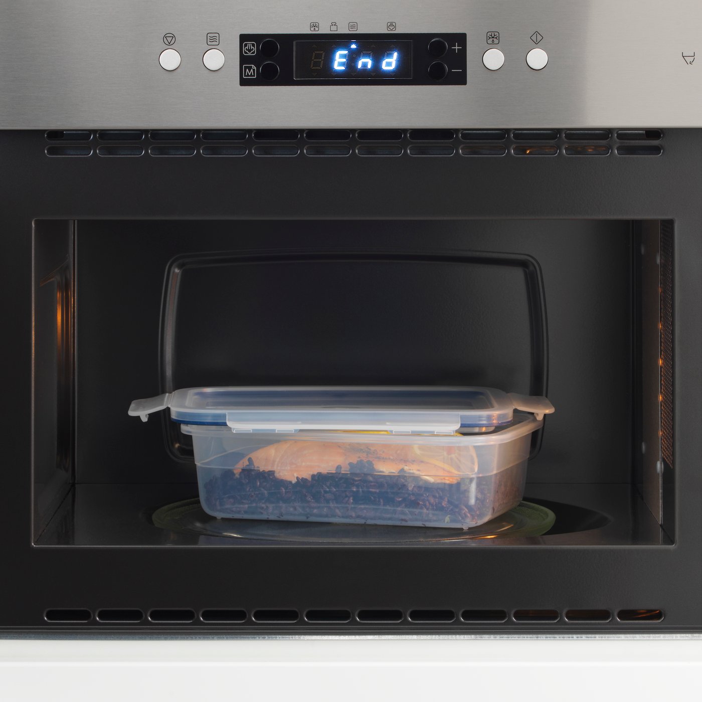 Plastová dóza s jídlem ohřívaná v mikrovlnné troubě.