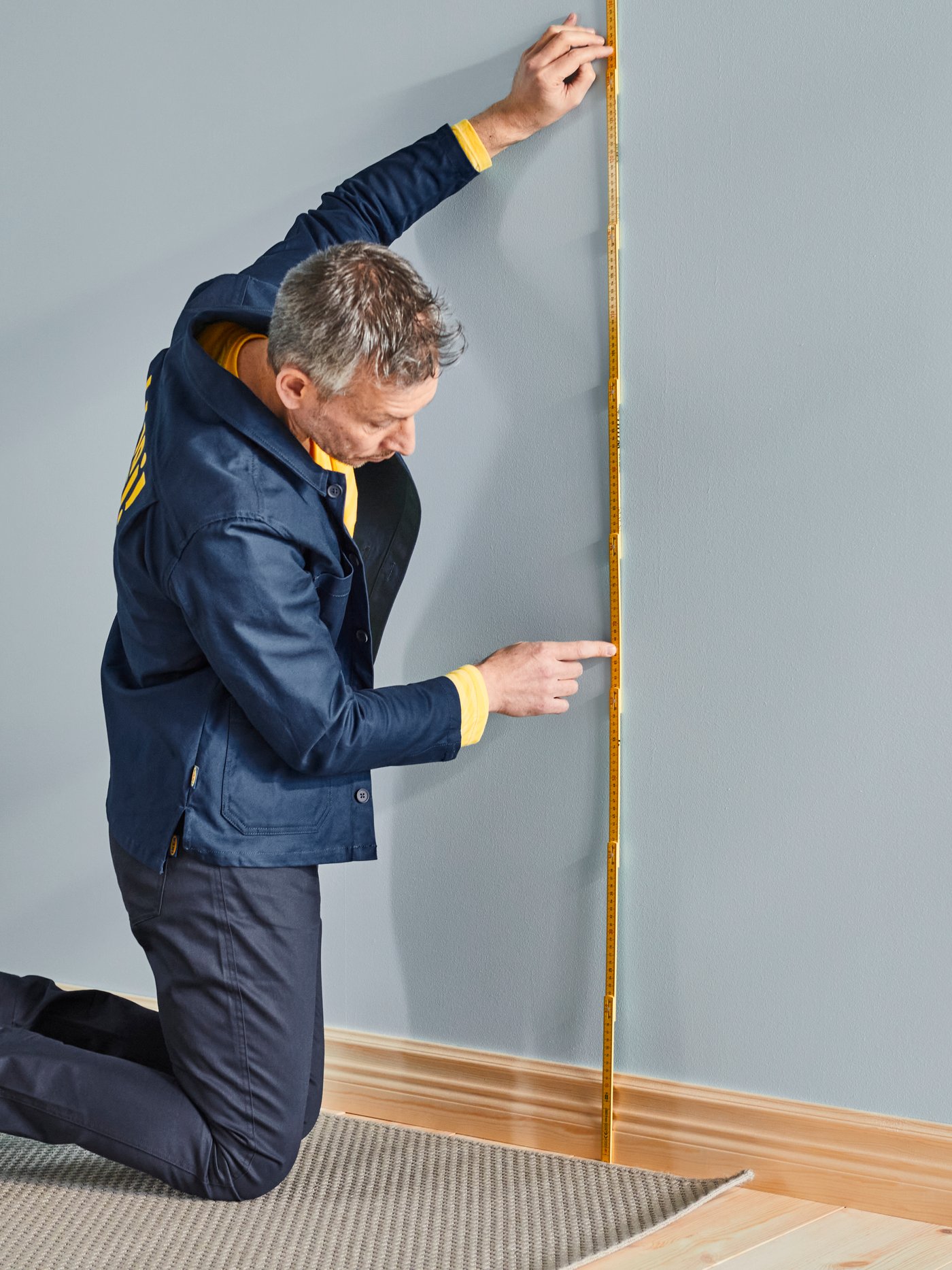 Zaměstnanec IKEA co měří stěnu.