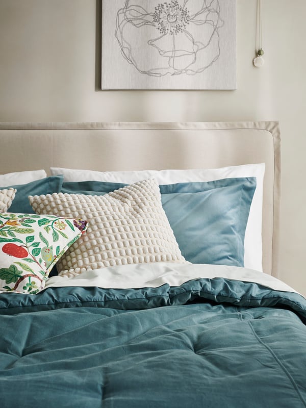 Close up of a TÄRNKULLEN bed dressed with SANELA comforter set and SANELA, SVARTPOPPEL and VILDPERSILJA cushions.
