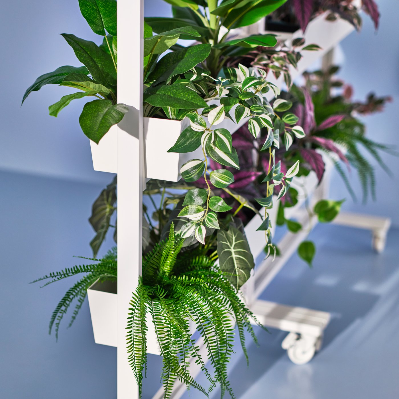 A MITTZON frame with castors and containers filled with FEJKA artificial potted plants.