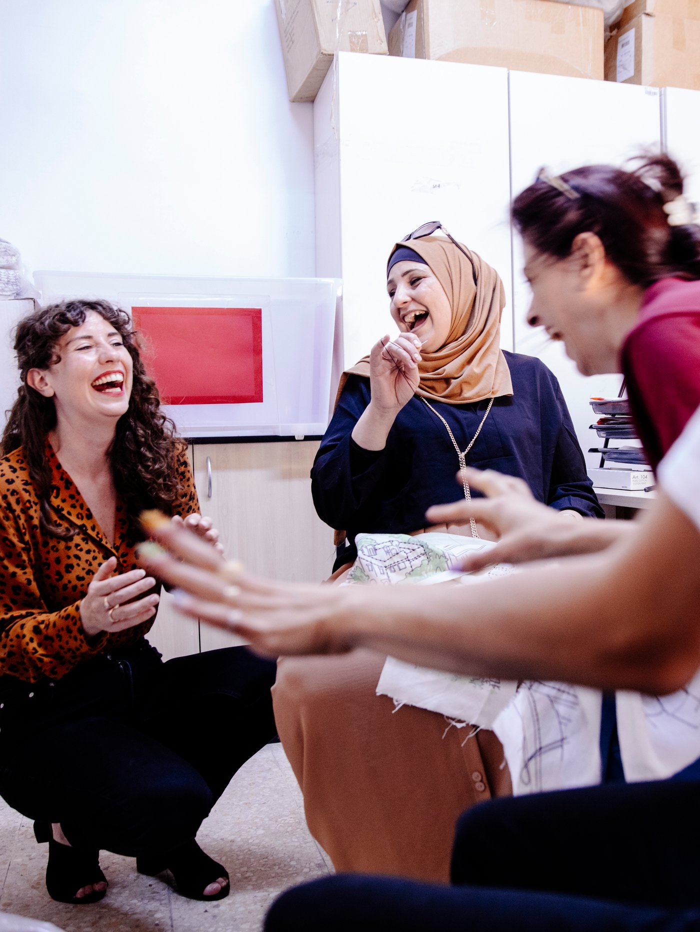 En medarbetare på IKEA och en hantverkare från Jordan River Foundation som skrattar på en workshop för formgivare.